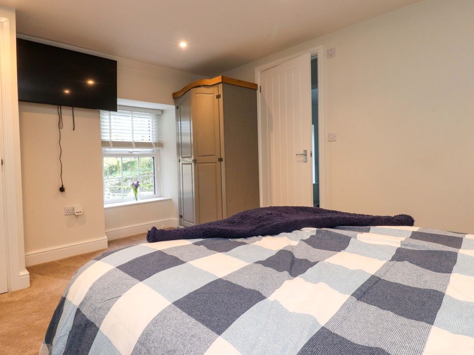 A bedroom with a bed and television at Cowside Farm in Langcliffe near Settle