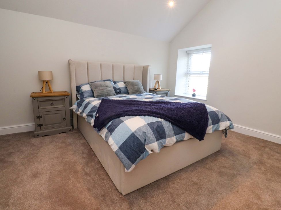 A bedroom with a bed and nightstand at Cowside Farm in Langcliffe near Settle