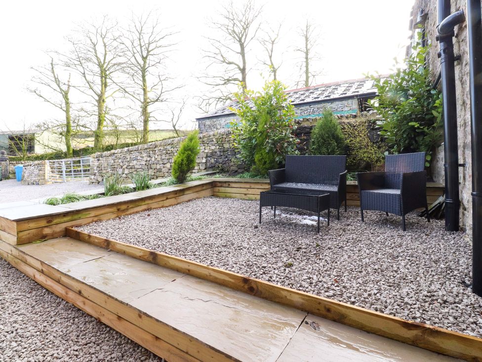 A garden area with gravel and two chairs at Cowside Farm in Langcliffe near Settle