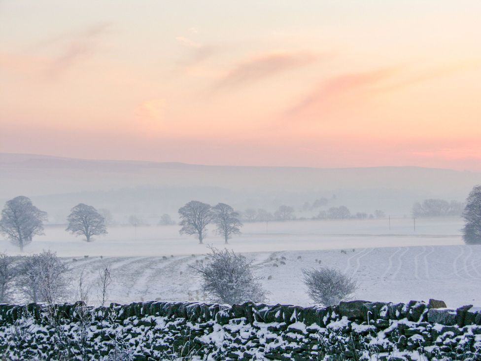 A snowy landscape with trees and a distant horizon at Cowside Farm Settle