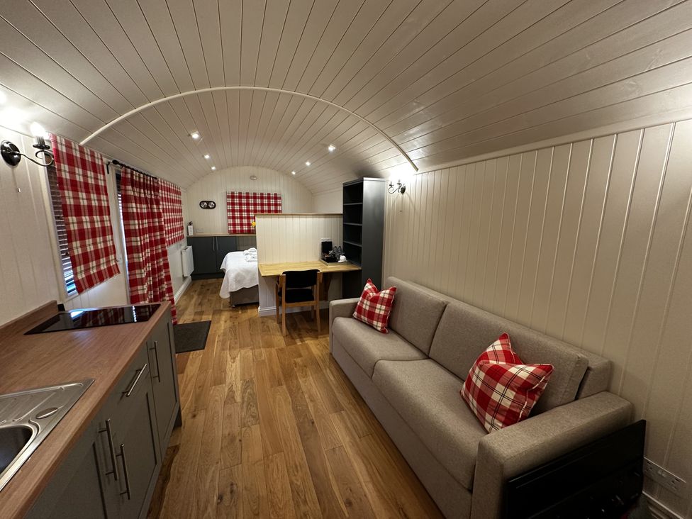A living room with a sofa and dining area at The Lodge in Upton Warren