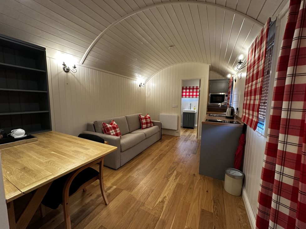A living room with a sofa and table at The Lodge in Upton Warren