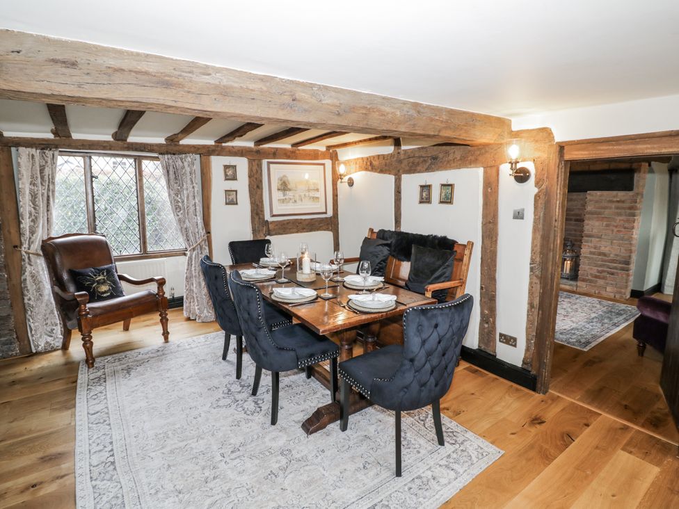 A dining room with a wooden table and chairs at Weston Cottage in Stratford-upon-Avon