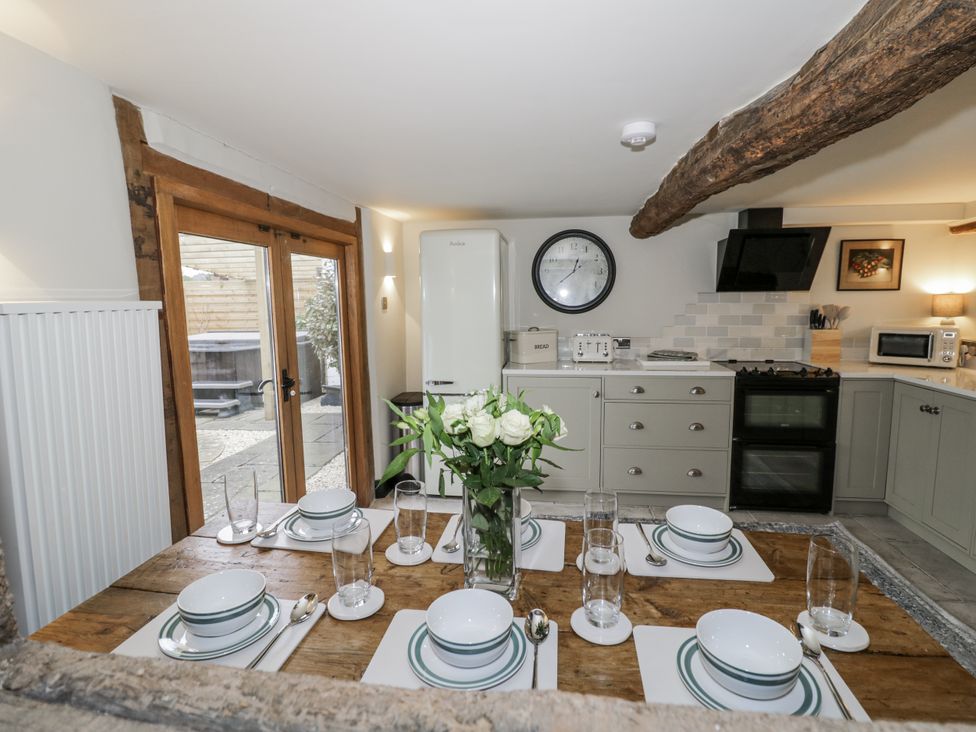 A kitchen with a dining table and dishes at Weston Cottage in Stratford-upon-Avon