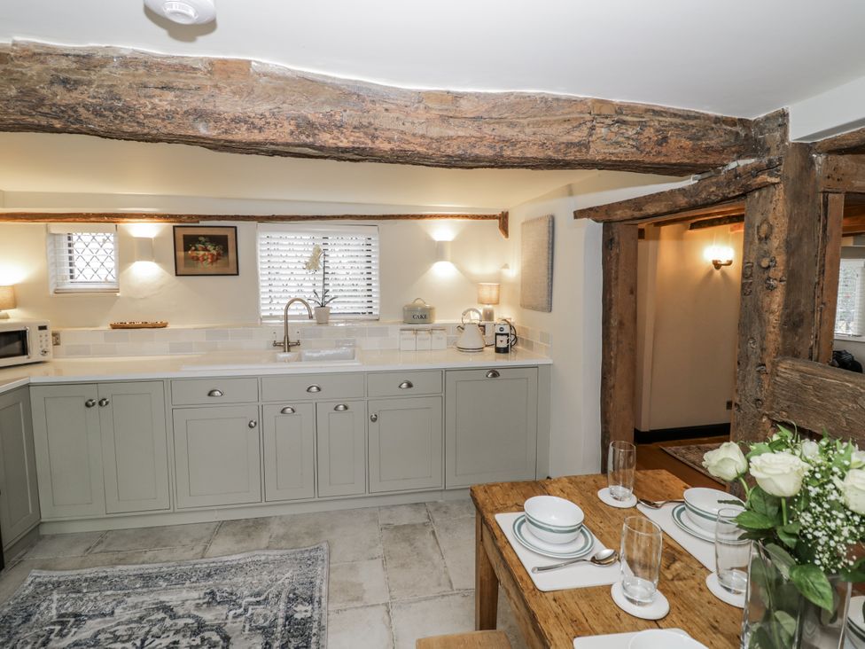 A kitchen with units and a dining area at Weston Cottage, Stratford-upon-Avon