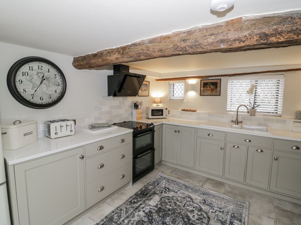 A kitchen with cabinets and appliances at Weston Cottage in Stratford-upon-Avon