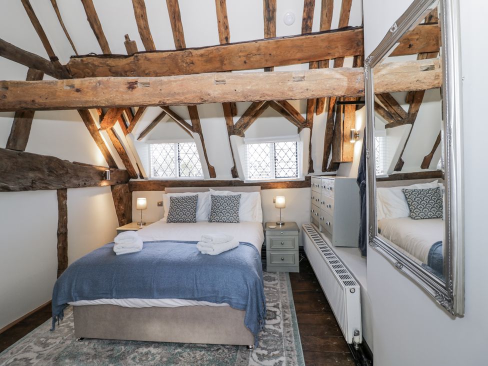 A bedroom with wooden beams and a bed at Weston Cottage in Stratford-upon-Avon