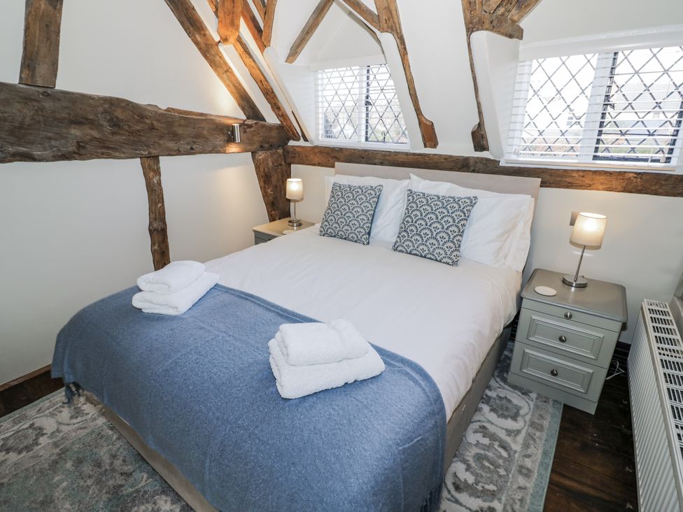 A bedroom with a bed and nightstand at Weston Cottage in Stratford-upon-Avon
