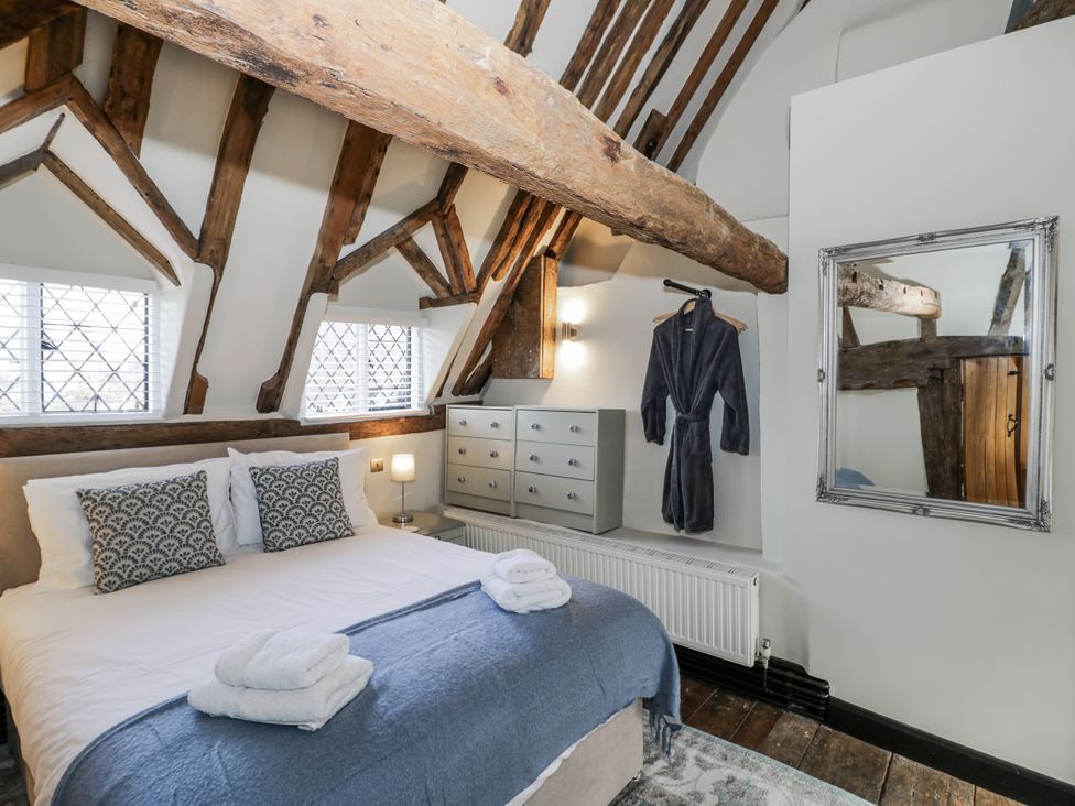 A bedroom with a bed and dresser at Weston Cottage in Stratford-upon-Avon