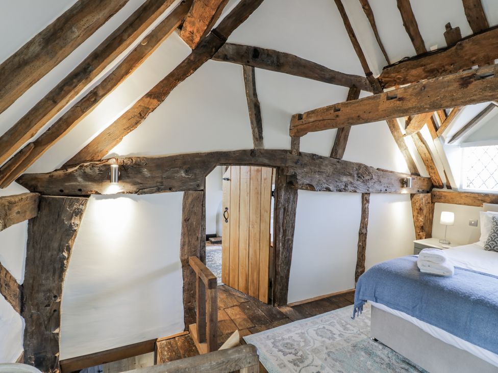 A bedroom with wooden beams and a bed at Weston Cottage in Stratford-upon-Avon