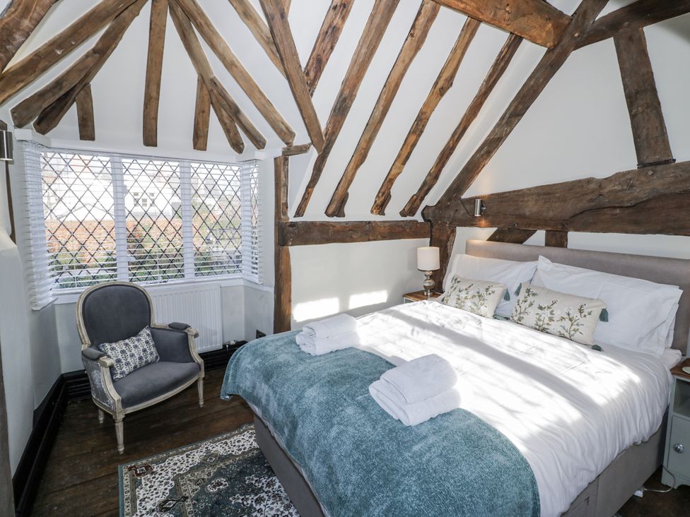 A bedroom with a bed and chair at Weston Cottage in Stratford-upon-Avon