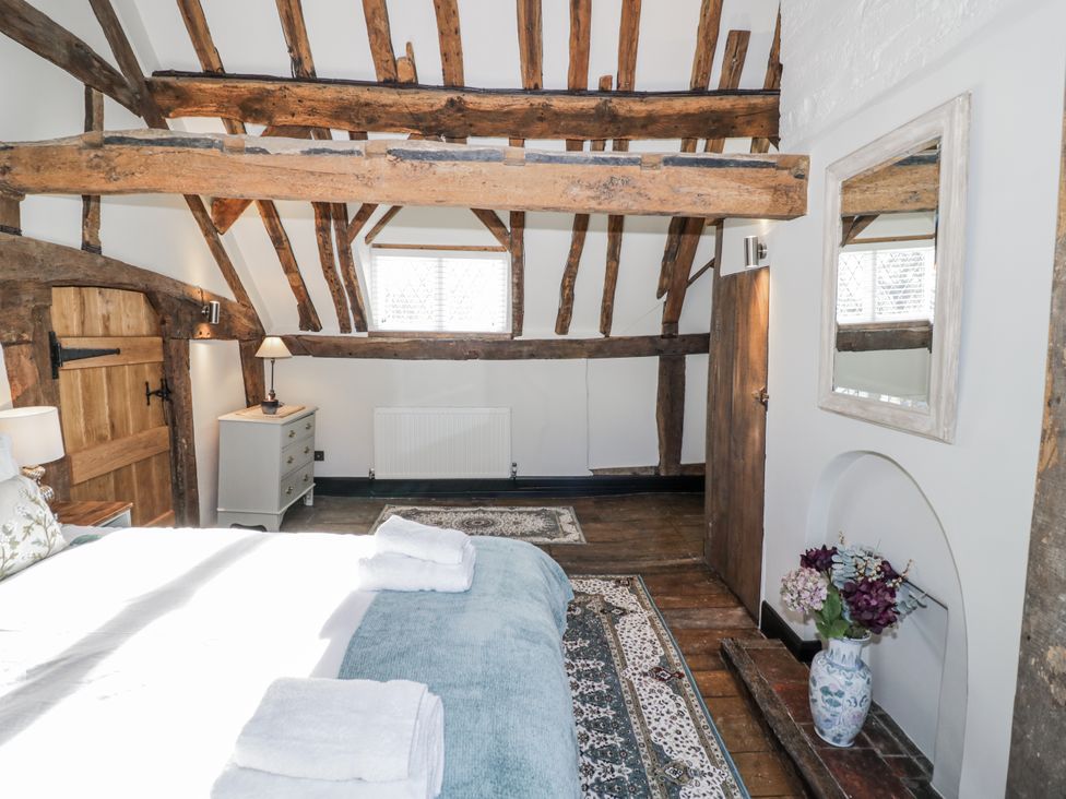 A bedroom with wooden beams and a rug at Weston Cottage in Stratford-upon-Avon