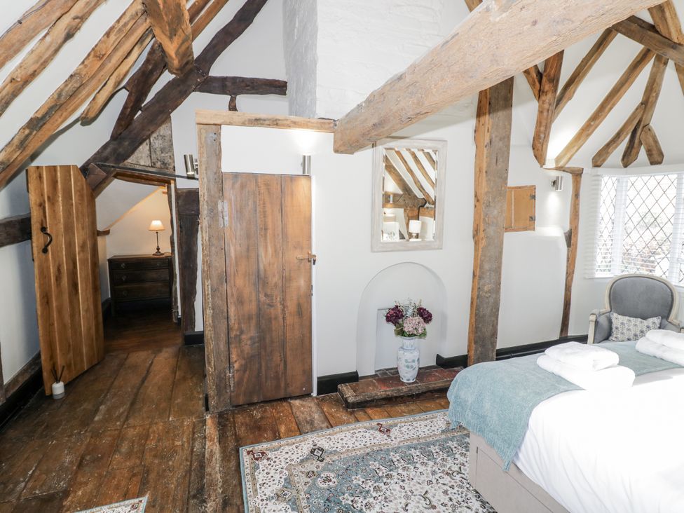 A bedroom with a bed and an armchair at Weston Cottage Stratford-upon-Avon