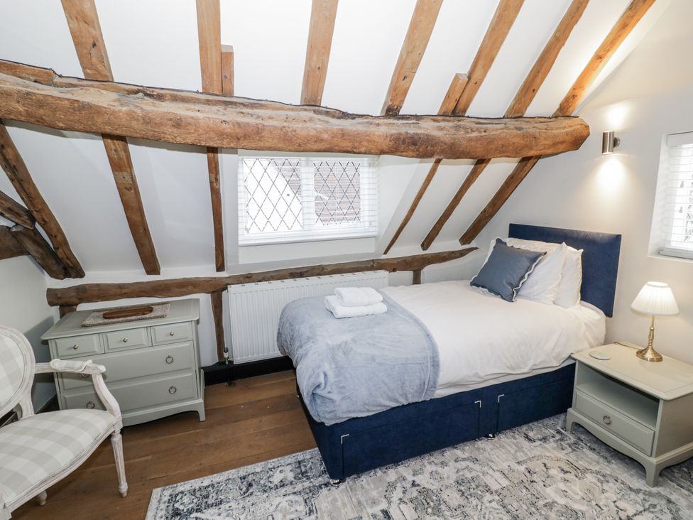 A bedroom with a single bed, dresser, and window at Weston Cottage in Stratford-upon-Avon