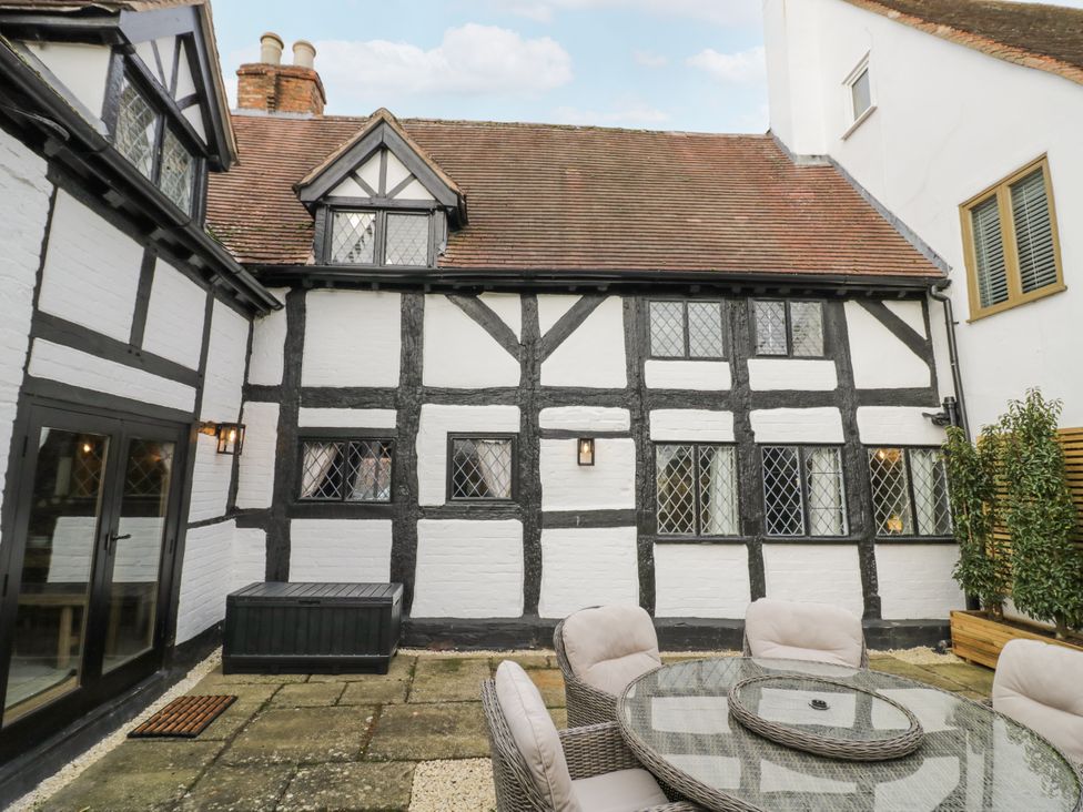 An outdoor seating area with a table and chairs at Weston Cottage Stratford-upon-Avon