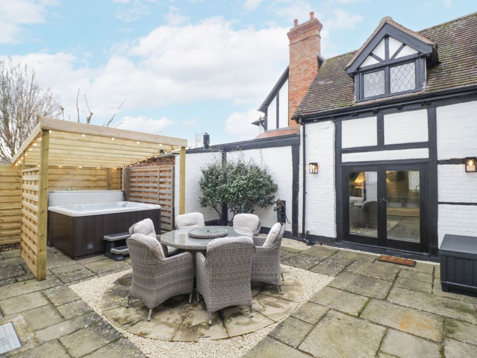 A garden with a hot tub and outdoor seating at Weston Cottage in Stratford-upon-Avon