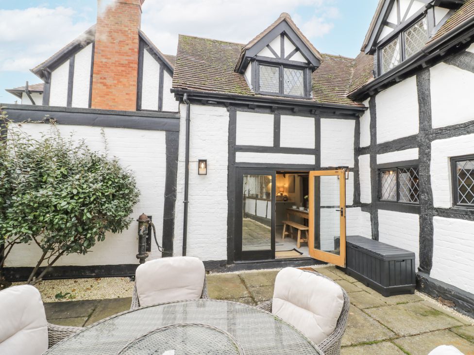 An outdoor patio area with a table and chairs at Weston Cottage in Stratford-upon-Avon
