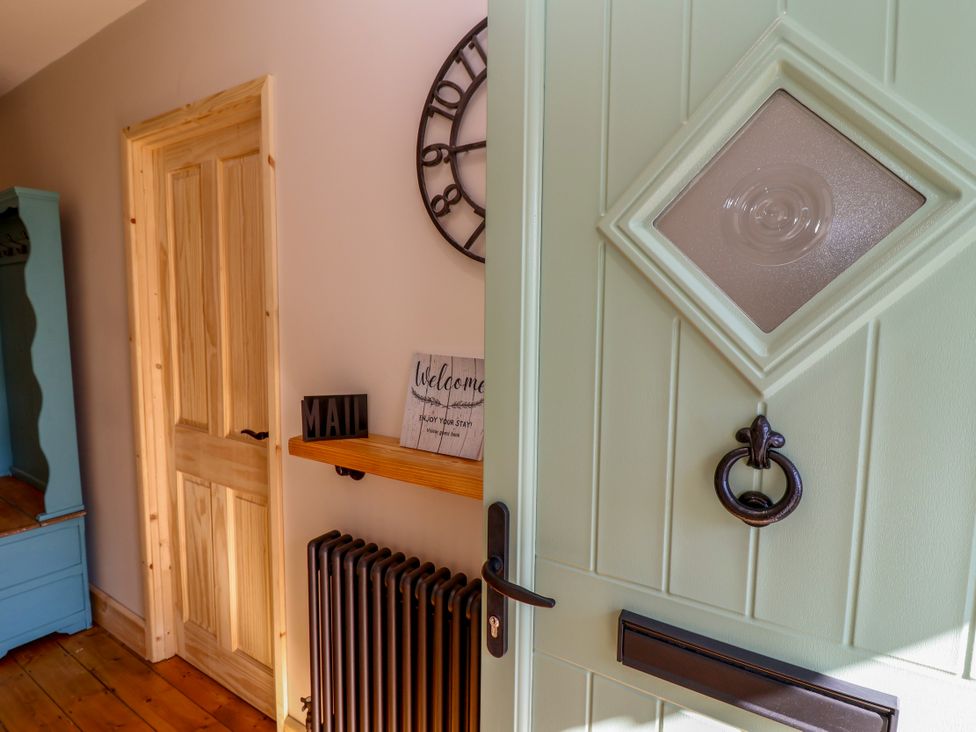 A hallway with a door and a shelf at 1 Ashcott Place in Burnham-On-Sea