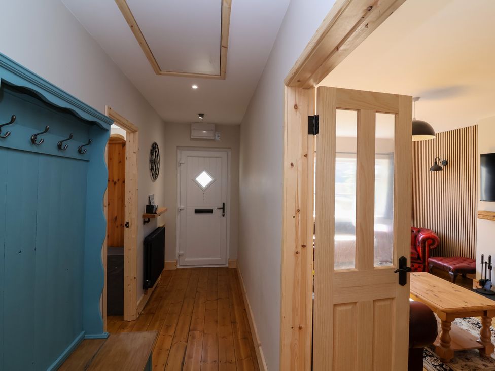 A hallway with a coat rack and front door at 1 Ashcott Place Burnham-On-Sea