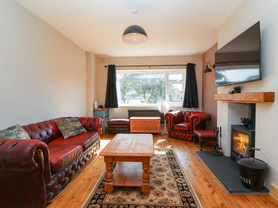 A living room with leather sofas and a coffee table at 1 Ashcott Place in Burnham-On-Sea