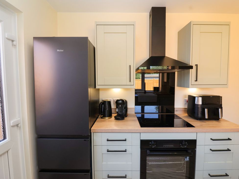A kitchen with appliances including a refrigerator and cooker at 1 Ashcott Place Burnham-On-Sea
