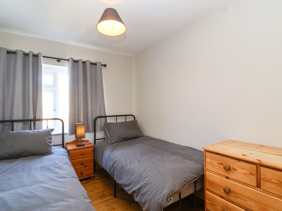 A bedroom with two beds and a window at 1 Ashcott Place Burnham-On-Sea