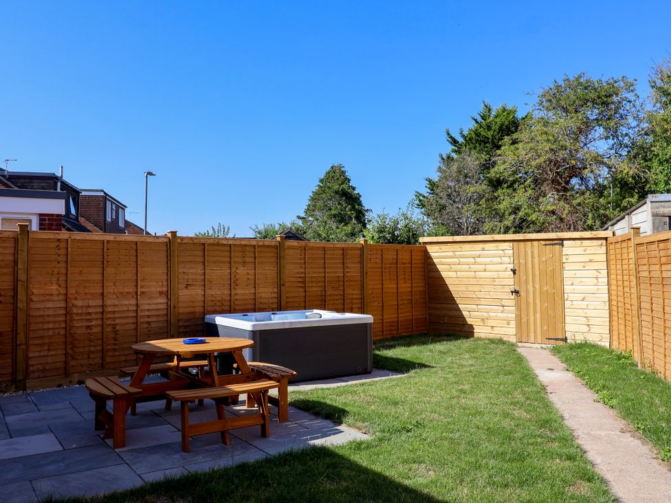 A garden with a hot tub and picnic table at 1 Ashcott Place in Burnham-On-Sea