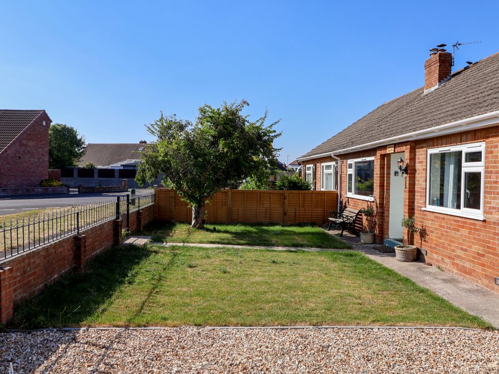A garden with grass and a tree at 1 Ashcott Place Burnham-On-Sea