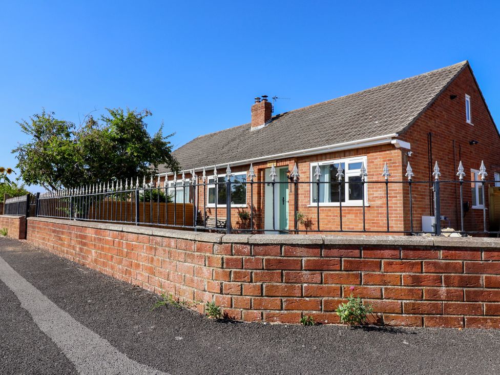 A house with a brick wall and fence at 1 Ashcott Place Burnham-On-Sea