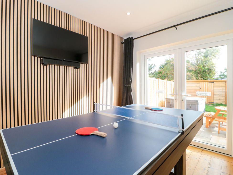 A game room with a ping pong table and television at 1 Ashcott Place in Burnham-On-Sea