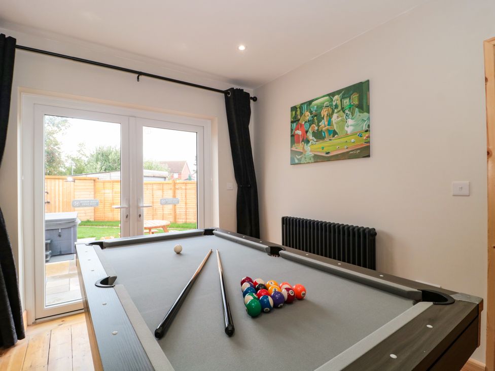 A game room with a pool table and sliding doors at 1 Ashcott Place in Burnham-On-Sea