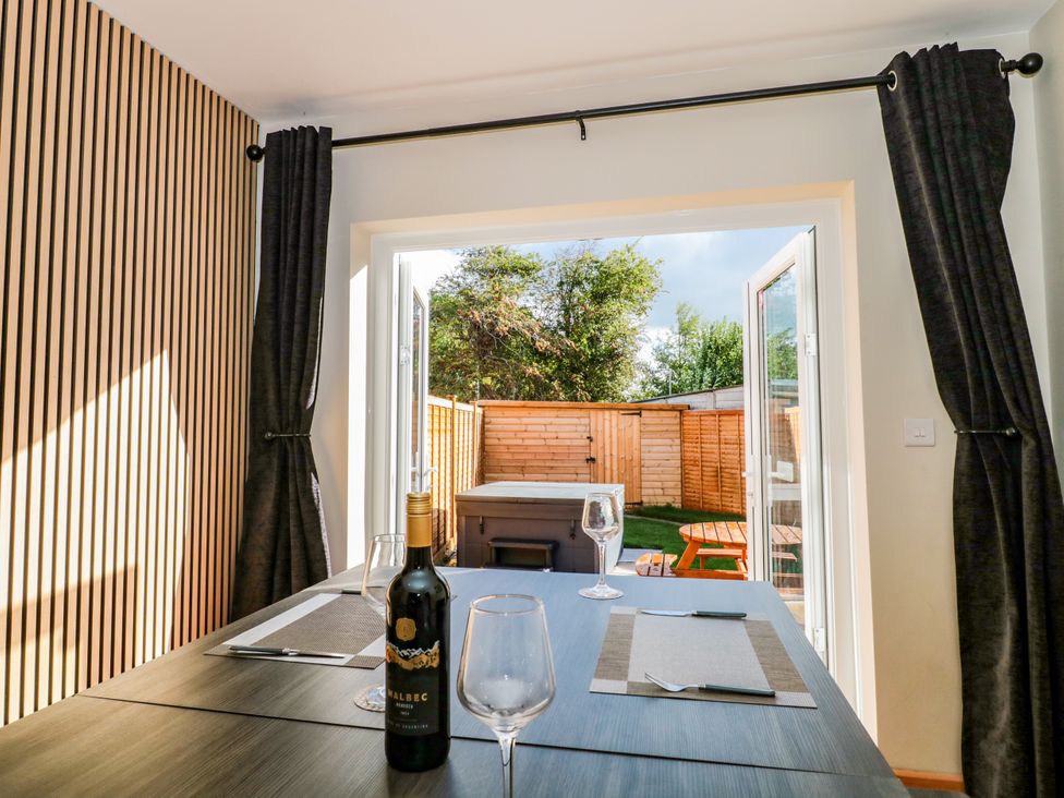 A dining room with a table and wine bottle at 1 Ashcott Place Burnham-On-Sea
