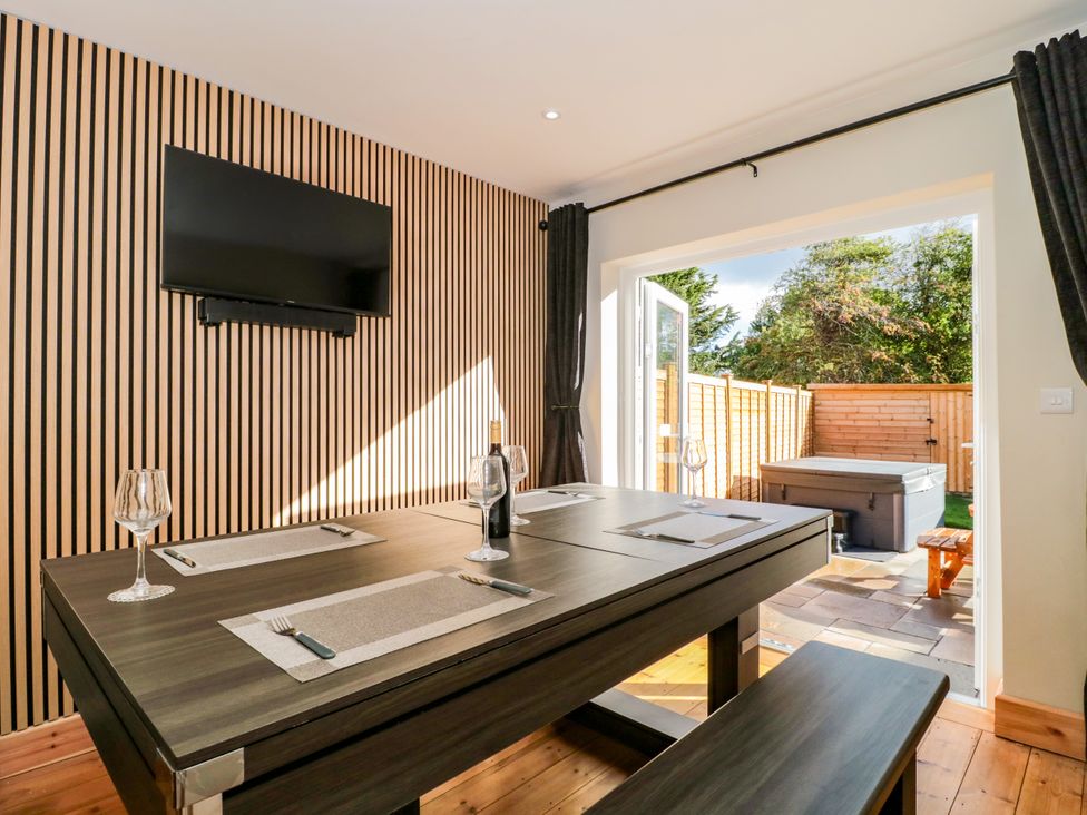 A dining room with a table and television at 1 Ashcott Place Burnham-On-Sea