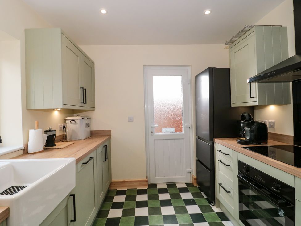A kitchen with cabinets, a sink, and appliances at 1 Ashcott Place Burnham-On-Sea