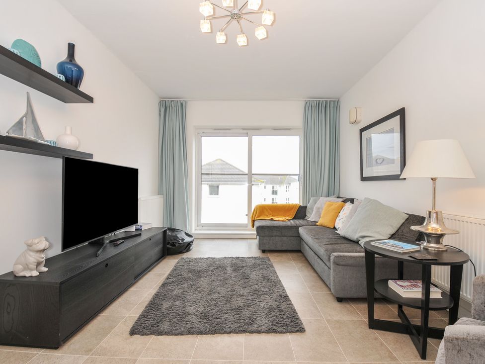 A living room with a sofa and television at Sea Snug in Newquay