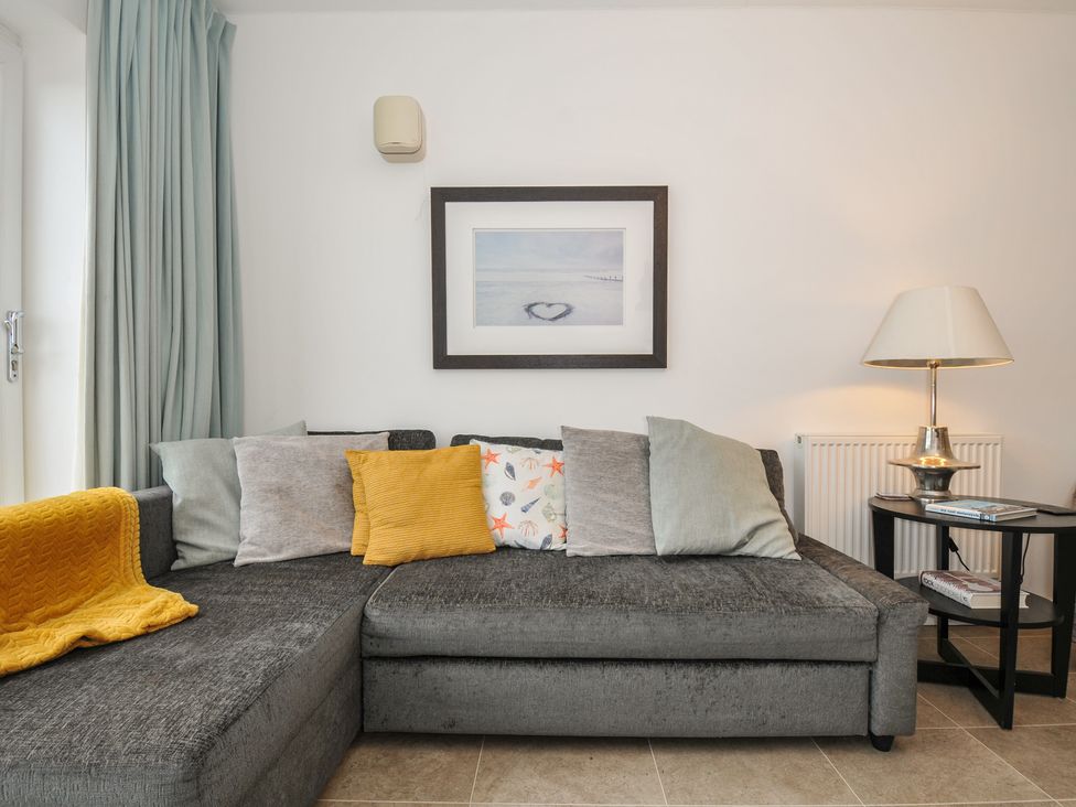 A living room with a sofa and cushions at Sea Snug in Newquay
