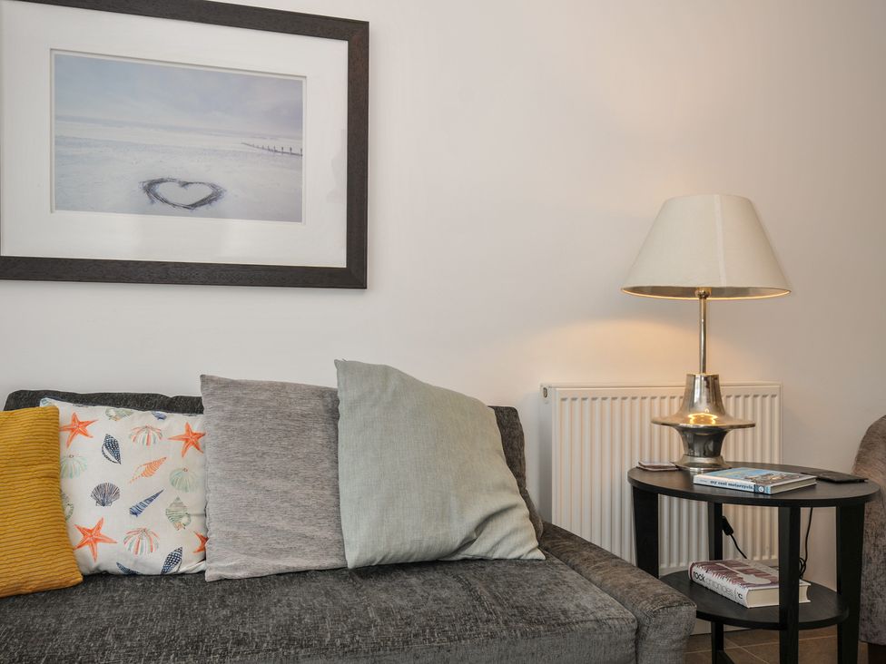 A living room with a sofa and lamp at Sea Snug in Newquay