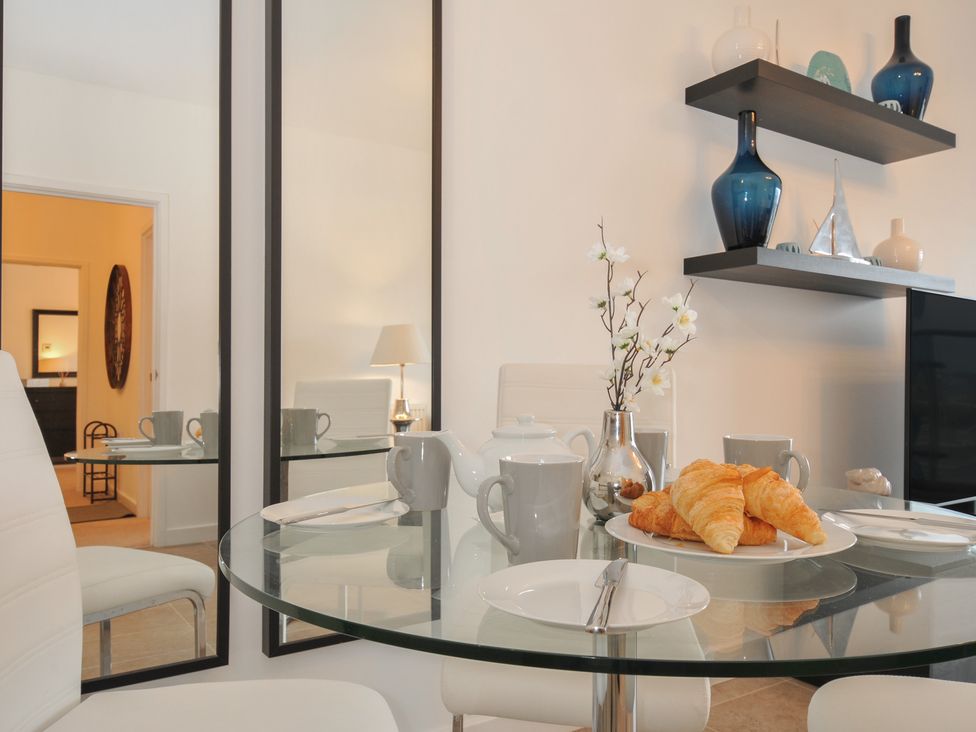 A dining table set with croissants and tea at Sea Snug in Newquay