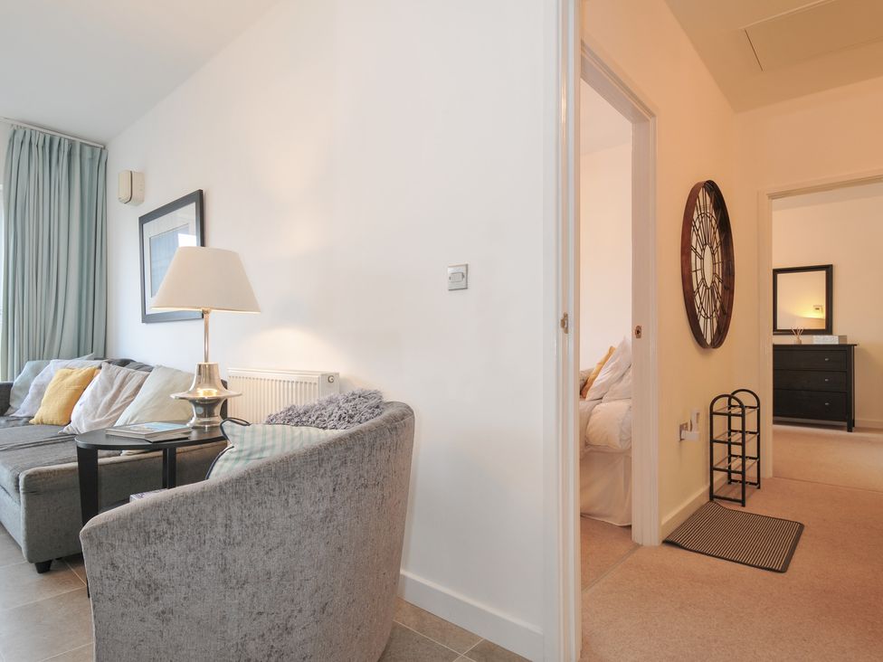 A living room with a sofa and lamp at Sea Snug in Newquay