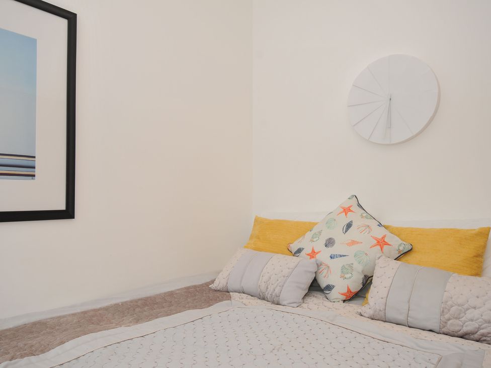 A bedroom with a bed and decorative pillows at Sea Snug in Newquay
