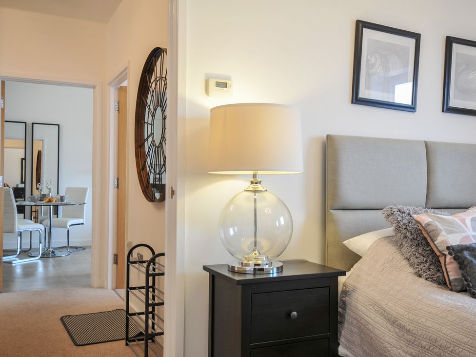 A bedroom with a lamp and nightstand at Sea Snug in Newquay
