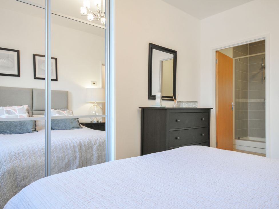 A bedroom with a bed and dresser at Sea Snug in Newquay