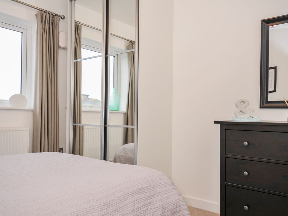 A bedroom with a bed and dresser at Sea Snug in Newquay