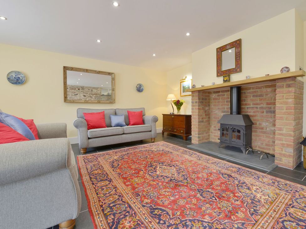 A living room with a sofa and fireplace at The Cider Barn at Home Farm Down Thomas near Wembury