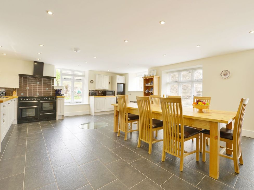 A kitchen with a dining table and chairs at The Cider Barn at Home Farm Down Thomas near Wembury