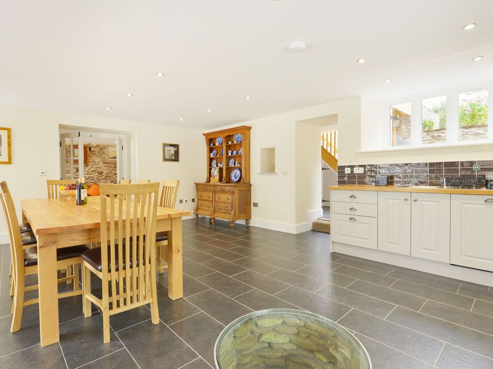 A kitchen with a dining table and sideboard at The Cider Barn at Home Farm Down Thomas near Wembury