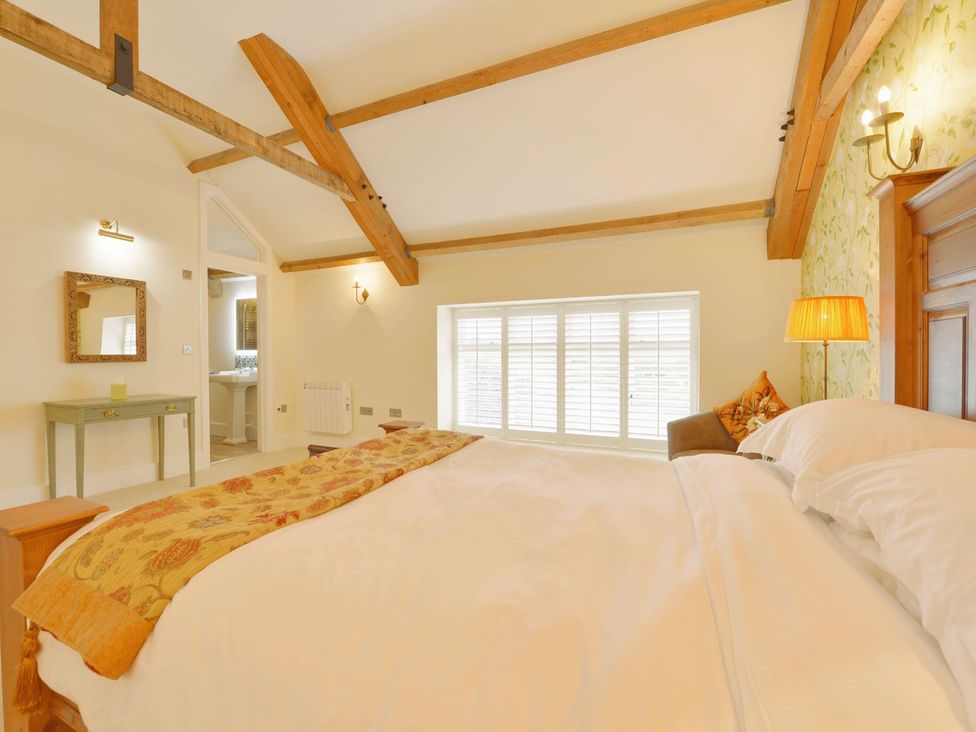 A bedroom with a bed and a table at The Cider Barn at Home Farm Down Thomas near Wembury