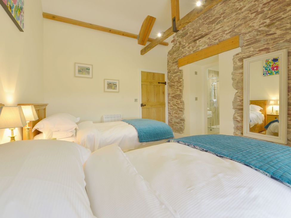 A bedroom with two beds and a lamp at The Cider Barn at Home Farm in Down Thomas near Wembury