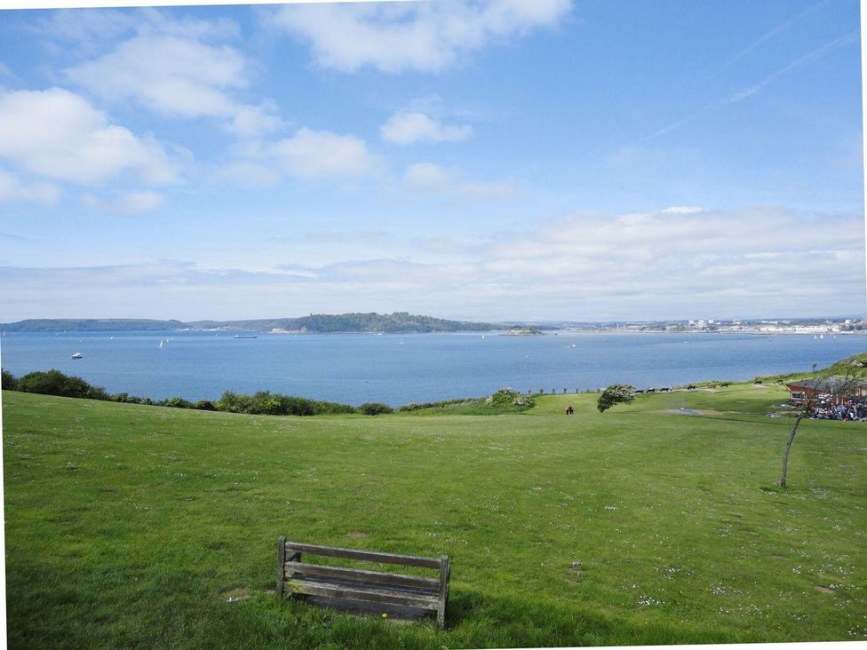 A view of a water body with boats and a bench at The Cider Barn at Home Farm Down Thomas near Wembury
