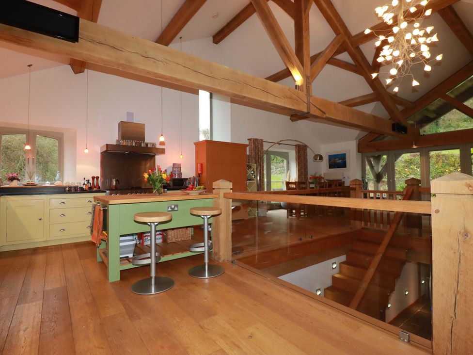A kitchen with a large island and bar stools at Kerslake House Crafthole